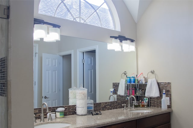 bathroom with vanity, backsplash, and vaulted ceiling