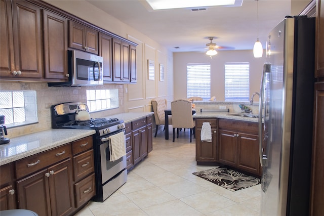 kitchen with decorative light fixtures, sink, dark brown cabinets, and stainless steel appliances