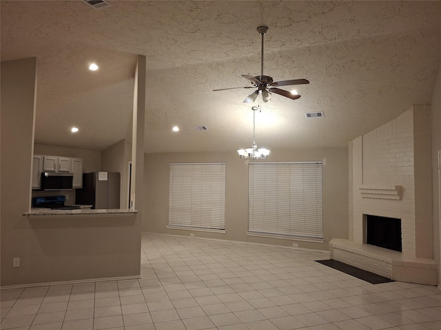 16703 Sentinel Dr, Houston, TX 77053 - unfurnished living room with vaulted ceiling, a textured ceiling, a ceiling fan, a fireplace, and a chandelier