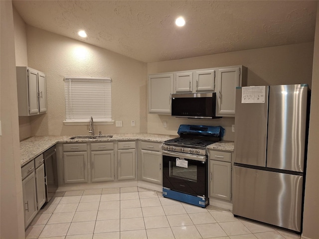 16703 Sentinel Dr, Houston, TX 77053 - kitchen with stainless steel appliances, a textured ceiling, light stone countertops, light tile patterned floors, and recessed lighting