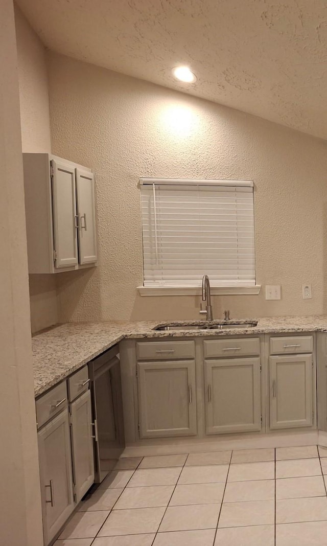 16703 Sentinel Dr, Houston, TX 77053 - kitchen with light tile patterned flooring, a textured wall, and gray cabinetry