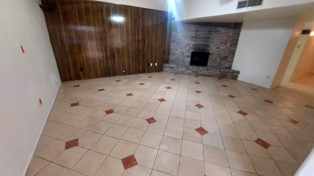 unfurnished living room featuring a fireplace and light tile patterned floors