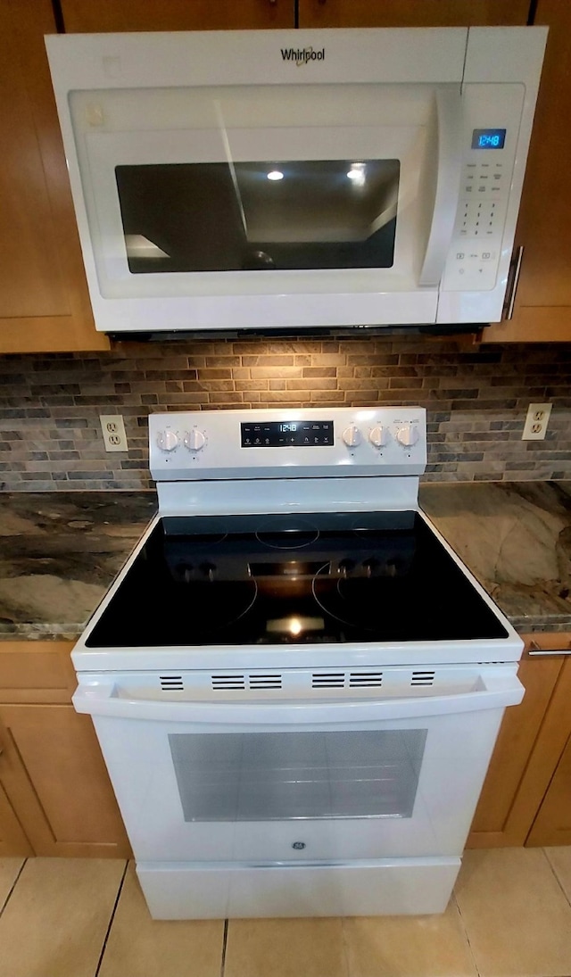 details with tile patterned flooring, white appliances, and tasteful backsplash