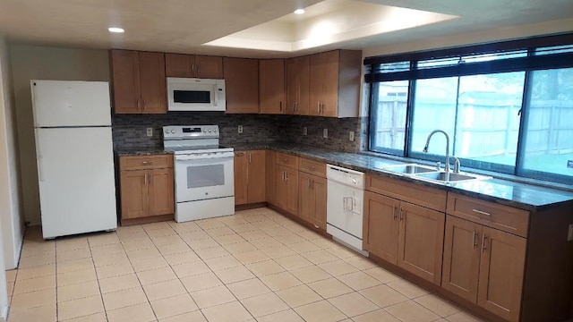 5538 W Ridgecreek Dr, Houston, TX 77053 - kitchen with white appliances, a sink, backsplash, a tray ceiling, and dark stone counters
