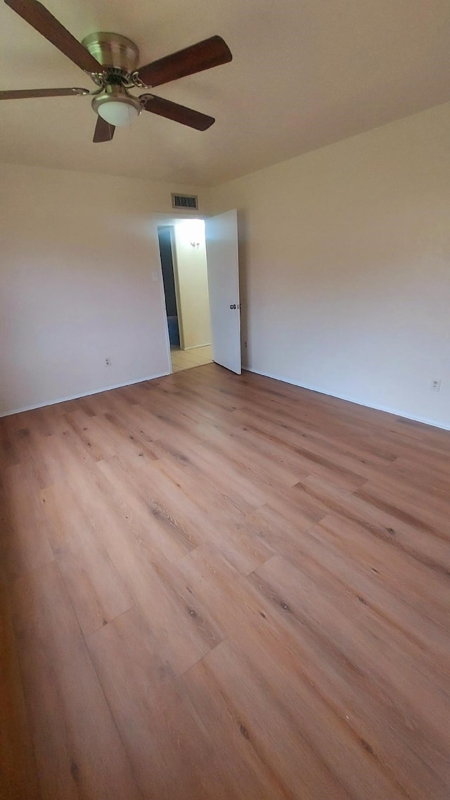 spare room with ceiling fan and light wood-type flooring