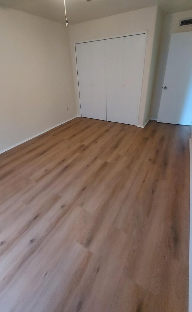 unfurnished bedroom with a closet and light hardwood / wood-style floors