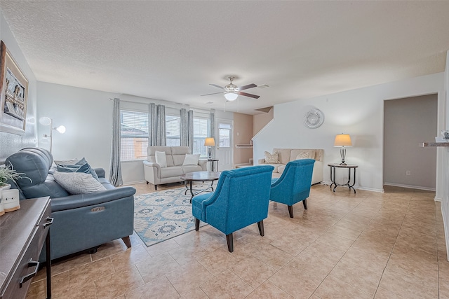 living room featuring light tile patterned flooring, a textured ceiling, and ceiling fan