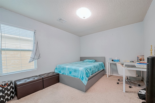 carpeted bedroom featuring multiple windows and a textured ceiling