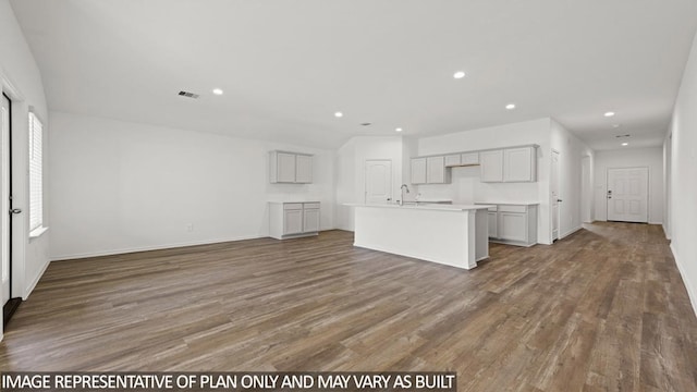 unfurnished living room with hardwood / wood-style floors and sink