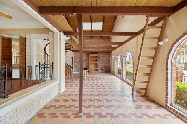 interior space featuring wooden ceiling, beamed ceiling, and brick wall