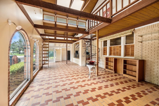 unfurnished sunroom with beamed ceiling and wood ceiling