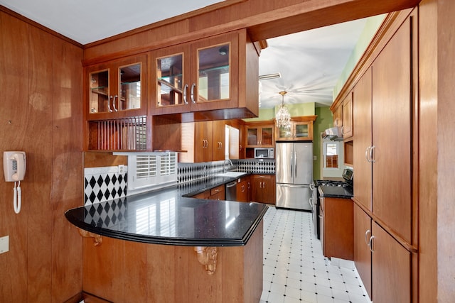 kitchen with stainless steel appliances, range hood, pendant lighting, sink, and kitchen peninsula