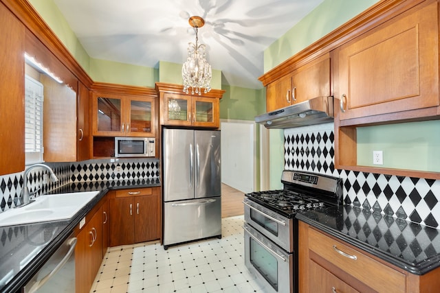 kitchen with decorative backsplash, a notable chandelier, sink, appliances with stainless steel finishes, and decorative light fixtures