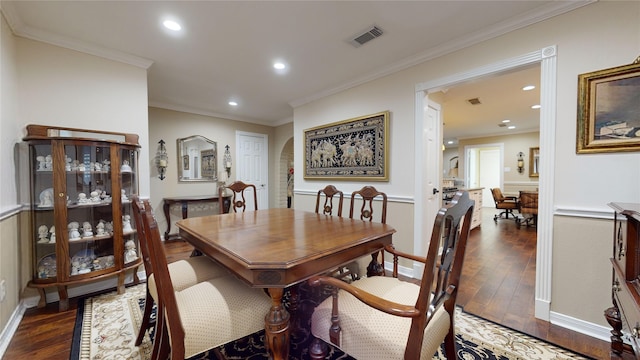 dining space featuring dark wood-type flooring and crown molding