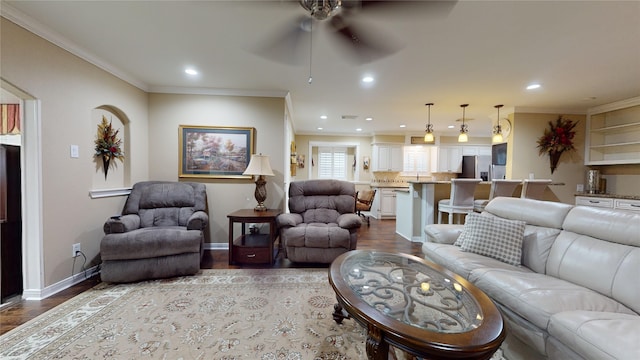 living room featuring ceiling fan, crown molding, and wood-type flooring