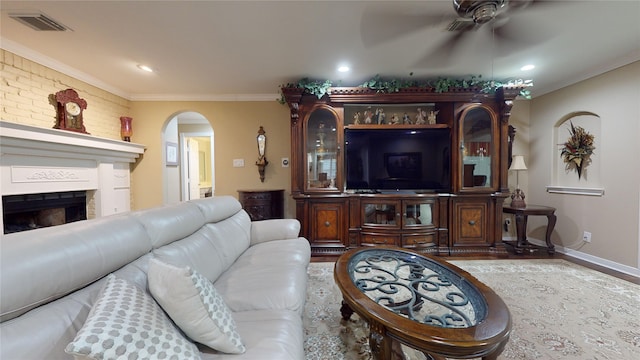 living room with hardwood / wood-style floors, ceiling fan, and crown molding