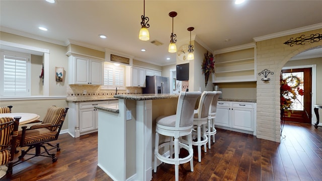 kitchen with white cabinets, stainless steel refrigerator with ice dispenser, and a healthy amount of sunlight