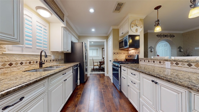 kitchen featuring stainless steel appliances, white cabinetry, sink, hanging light fixtures, and dark hardwood / wood-style flooring