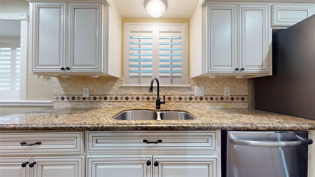 kitchen with light stone counters, sink, decorative backsplash, and dishwasher