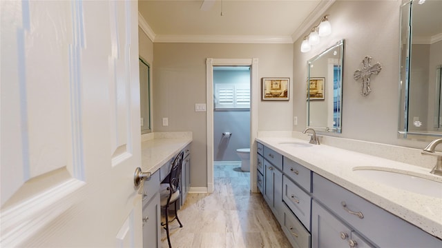 bathroom featuring toilet, vanity, and crown molding