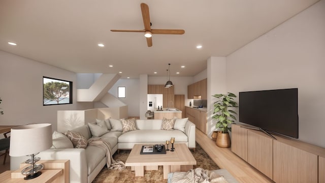 living room featuring ceiling fan and light hardwood / wood-style floors