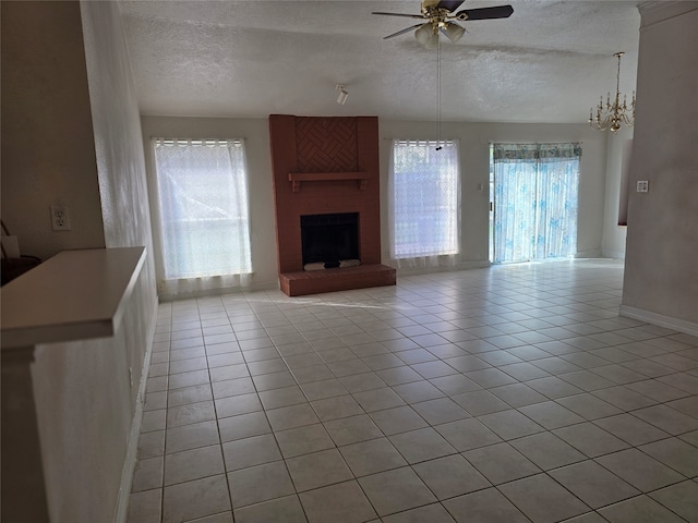 unfurnished living room featuring light tile patterned flooring, a textured ceiling, and a healthy amount of sunlight