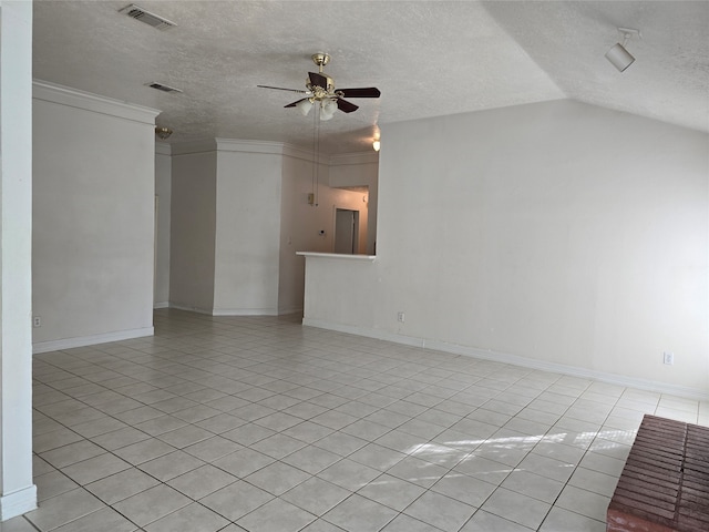 tiled spare room featuring ceiling fan, a textured ceiling, vaulted ceiling, and crown molding