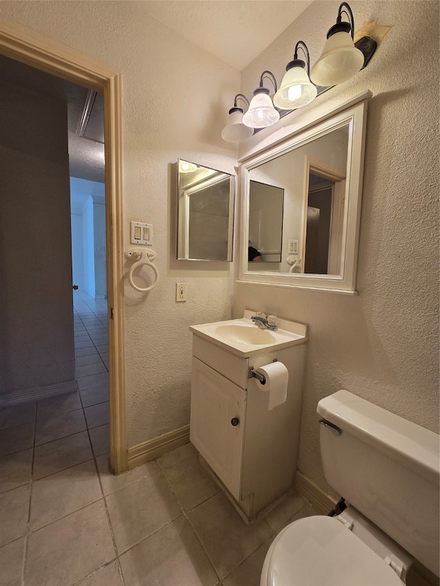 bathroom featuring toilet, vanity, and tile patterned floors