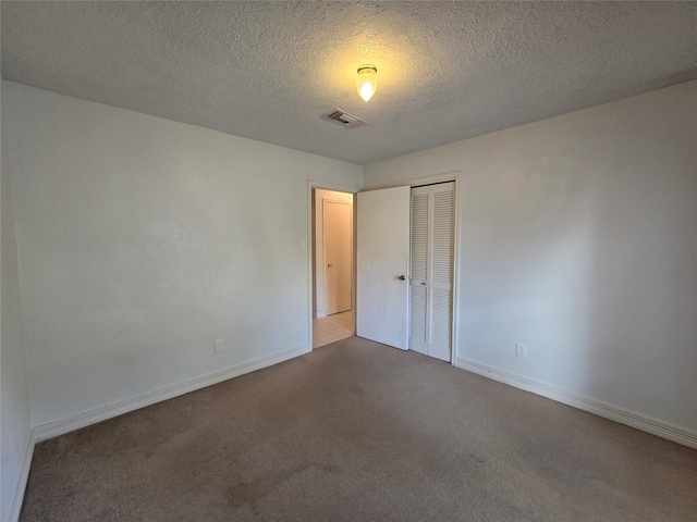 carpeted empty room with a textured ceiling