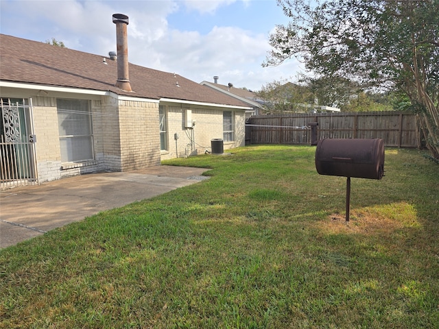 view of yard with central AC unit and a patio area