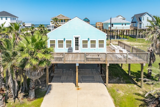 view of front of home featuring a wooden deck, a front yard, and a carport