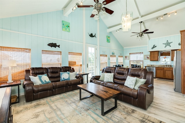 living room with light hardwood / wood-style floors, high vaulted ceiling, rail lighting, ceiling fan, and beam ceiling