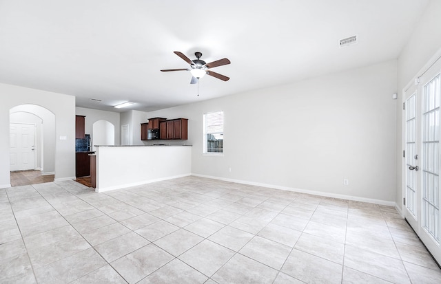 unfurnished living room with light tile patterned floors and ceiling fan