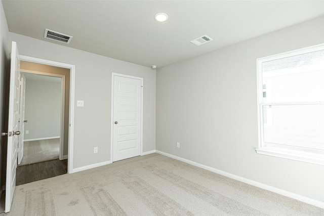 unfurnished bedroom with light carpet and a closet