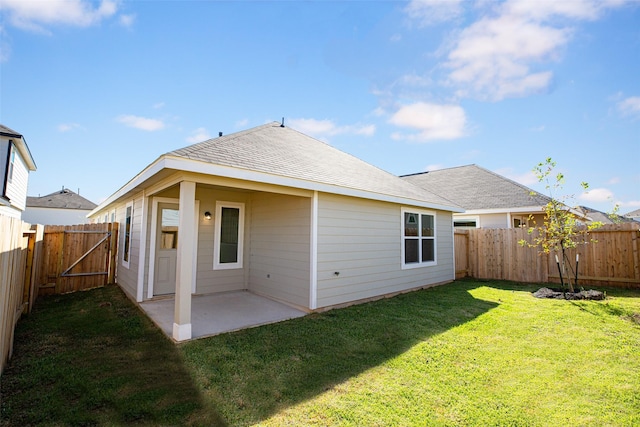 back of house with a patio area and a yard