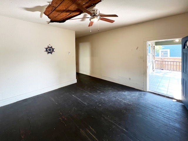 unfurnished room featuring dark wood-type flooring and ceiling fan