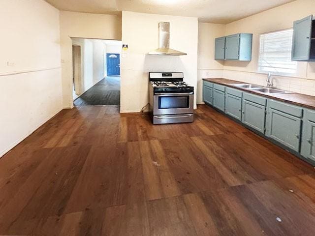 2251 Burnet St, San Antonio, TX 78202 - kitchen featuring stainless steel range with gas stovetop, wall chimney range hood, a sink, blue cabinets, and dark wood finished floors