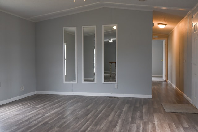 unfurnished room with dark hardwood / wood-style flooring, vaulted ceiling, and ornamental molding