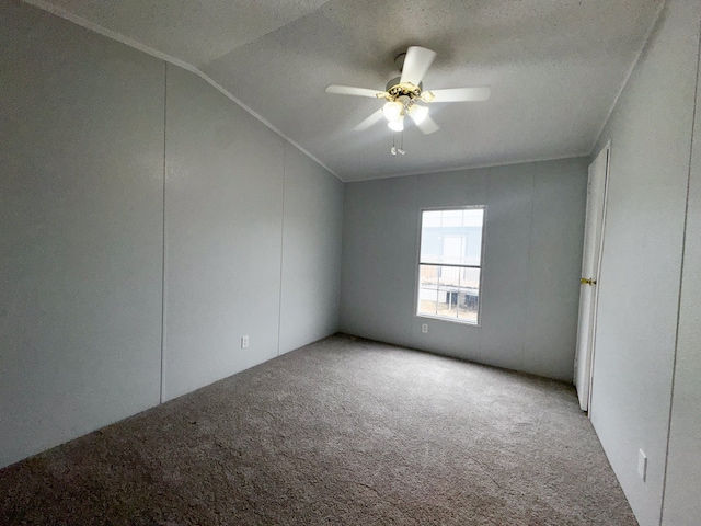 carpeted spare room featuring vaulted ceiling, ceiling fan, and a textured ceiling