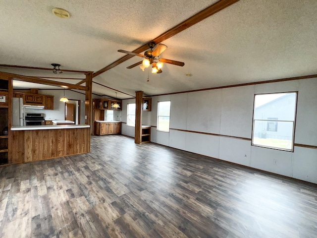 unfurnished living room featuring lofted ceiling with beams, a healthy amount of sunlight, a textured ceiling, and dark hardwood / wood-style flooring