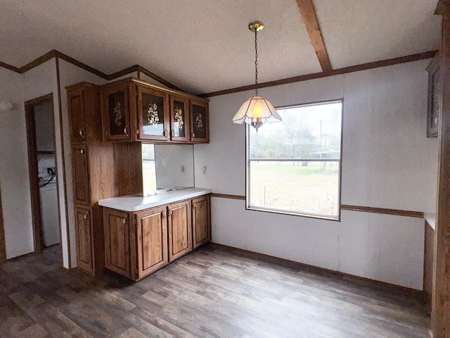 kitchen featuring pendant lighting, wood-type flooring, a textured ceiling, and vaulted ceiling