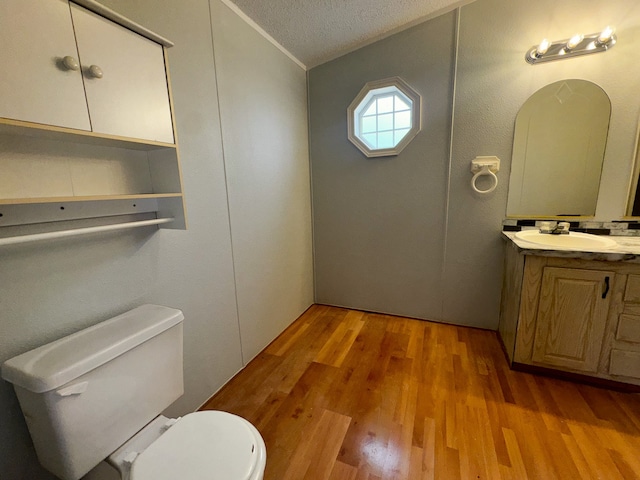 bathroom featuring hardwood / wood-style floors, vanity, a textured ceiling, and toilet