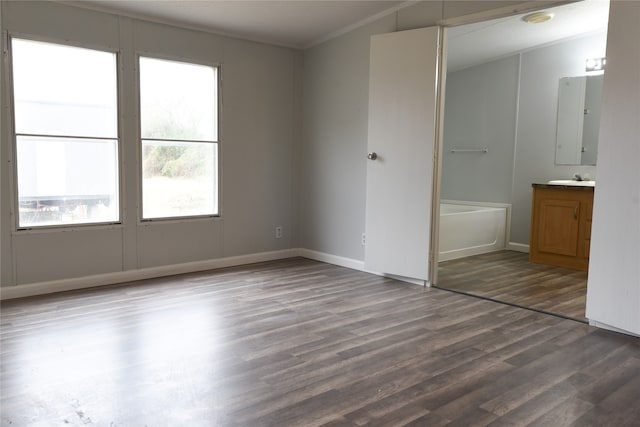 unfurnished bedroom with connected bathroom, vaulted ceiling, and hardwood / wood-style flooring