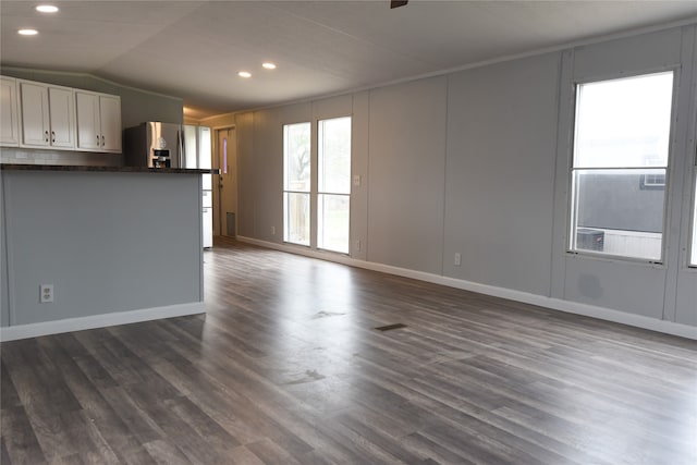 unfurnished living room with dark wood-type flooring, vaulted ceiling, and ceiling fan