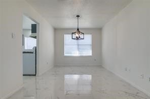 unfurnished dining area featuring an inviting chandelier