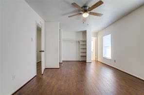 unfurnished bedroom featuring dark wood-type flooring, a closet, and ceiling fan