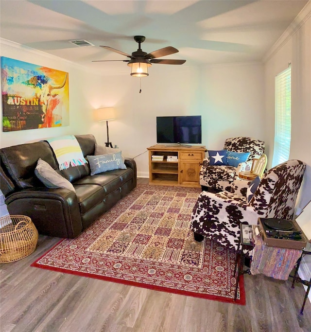 living room featuring hardwood / wood-style flooring, ceiling fan, and crown molding