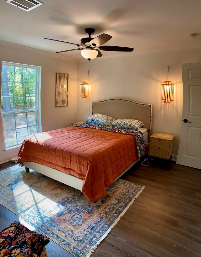 bedroom featuring ceiling fan, crown molding, and dark hardwood / wood-style flooring