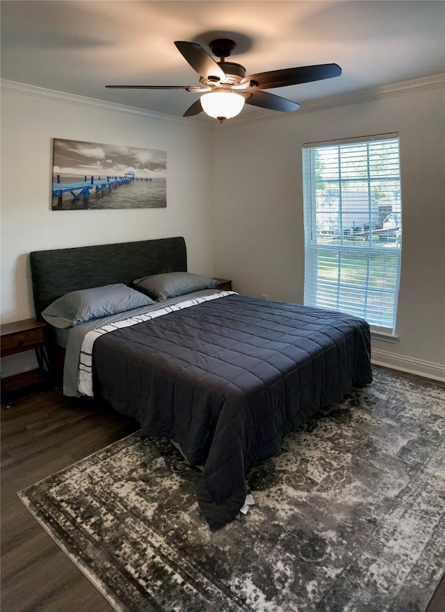 bedroom with crown molding, ceiling fan, and dark hardwood / wood-style floors