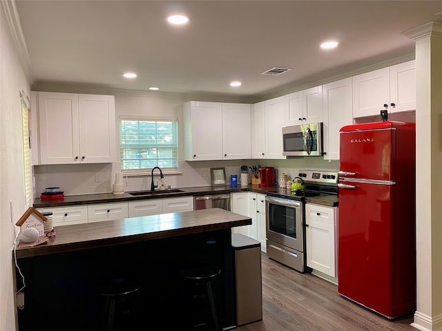 kitchen with white cabinetry, appliances with stainless steel finishes, sink, and dark hardwood / wood-style floors